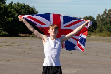 Formda ve sportif genç bir çocuk sıcak bir yaz gününde dışarıda şınav çekiyor.