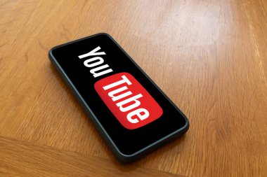 Londra, Birleşik Krallık, 5 Eylül 2023: - Bir Youtube logosunu gösteren ahşap bir masanın üzerinde bir cep telefonu