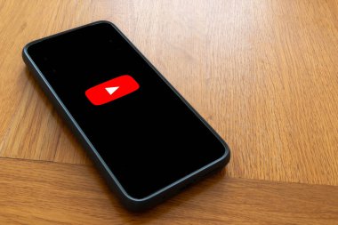 Londra, Birleşik Krallık, 5 Eylül 2023: - Bir Youtube logosunu gösteren ahşap bir masanın üzerinde bir cep telefonu
