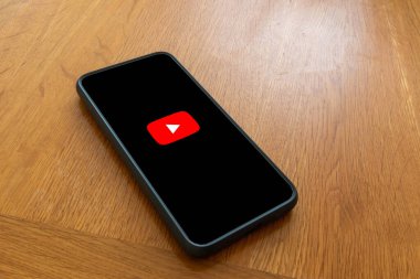 Londra, Birleşik Krallık, 5 Eylül 2023: - Bir Youtube logosunu gösteren ahşap bir masanın üzerinde bir cep telefonu