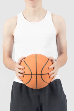 Elinde basketbol topu tutan beyaz bir çocuk.