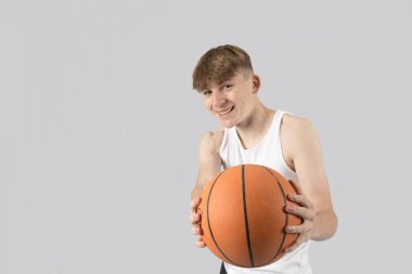 Elinde basketbol topu tutan beyaz bir çocuk.