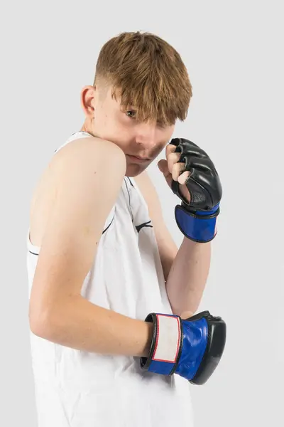 防御上のMmaスタイルのボクシング手袋を身に着けている慎重な十代の少年 — ストック写真