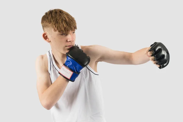 Mmaスタイルのボクシンググローブパンチを着用する慎重な十代の少年 — ストック写真