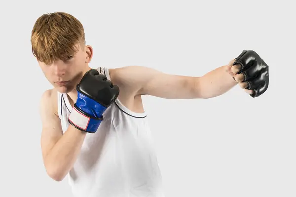 Mmaスタイルのボクシンググローブパンチを着用する慎重な十代の少年 — ストック写真