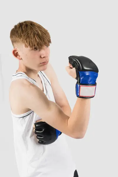 Mmaスタイルのボクシンググローブを着用している慎重な十代の少年は 上部カットを打つ — ストック写真