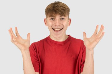 Mutlu ve şaşırmış on beş yaşındaki bir çocuğun stüdyo portresi.