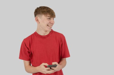 Mutlu genç çocuk cep telefonuna mesaj yazıyor.