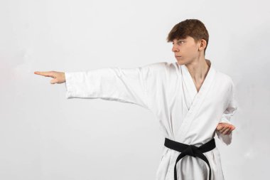 15 yaşında bir Karate Siyah Kemeri çocuğu, A Gi giyip kata yapıyor.