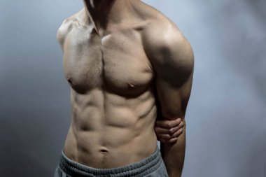 Karın kasları ve göğsü iyi tanımlanmış genç bir erkek cesedi. Gömleksiz gövdeli bir model. Vücut bakımı, erkek sağlığı, fitness, gençlik, erkeklik, sağlık, kilo kaybı, vücut geliştirme 