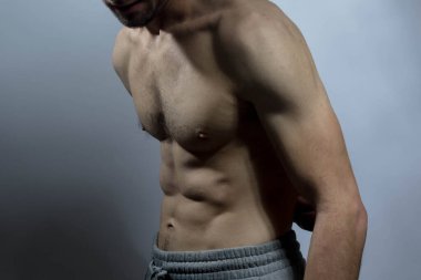 Karın kasları ve göğsü iyi tanımlanmış genç bir erkek cesedi. Gömleksiz gövdeli bir model. Vücut bakımı, erkek sağlığı, fitness, gençlik, erkeklik, sağlık, kilo kaybı, vücut geliştirme 