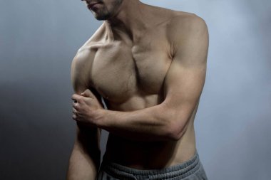 Karın kasları ve göğsü iyi tanımlanmış genç bir erkek cesedi. Gömleksiz gövdeli bir model. Vücut bakımı, erkek sağlığı, fitness, gençlik, erkeklik, sağlık, kilo kaybı, vücut geliştirme 