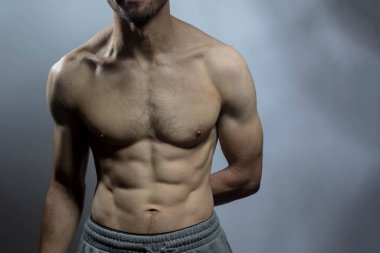 Karın kasları ve göğsü iyi tanımlanmış genç bir erkek cesedi. Gömleksiz gövdeli bir model. Vücut bakımı, erkek sağlığı, fitness, gençlik, erkeklik, sağlık, kilo kaybı, vücut geliştirme 