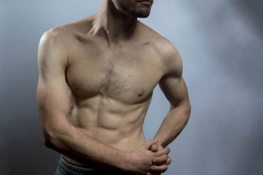 Karın kasları ve göğsü iyi tanımlanmış genç bir erkek cesedi. Gömleksiz gövdeli bir model. Vücut bakımı, erkek sağlığı, fitness, gençlik, erkeklik, sağlık, kilo kaybı, vücut geliştirme 