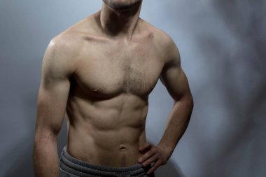 Karın kasları ve göğsü iyi tanımlanmış genç bir erkek cesedi. Gömleksiz gövdeli bir model. Vücut bakımı, erkek sağlığı, fitness, gençlik, erkeklik, sağlık, kilo kaybı, vücut geliştirme 