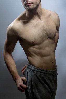 Karın kasları ve göğsü iyi tanımlanmış genç bir erkek cesedi. Gömleksiz gövdeli bir model. Vücut bakımı, erkek sağlığı, fitness, gençlik, erkeklik, sağlık, kilo kaybı, vücut geliştirme 