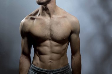 Karın kasları ve göğsü iyi tanımlanmış genç bir erkek cesedi. Gömleksiz gövdeli bir model. Vücut bakımı, erkek sağlığı, fitness, gençlik, erkeklik, sağlık, kilo kaybı, vücut geliştirme 