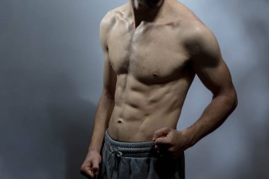 Karın kasları ve göğsü iyi tanımlanmış genç bir erkek cesedi. Gömleksiz gövdeli bir model. Vücut bakımı, erkek sağlığı, fitness, gençlik, erkeklik, sağlık, kilo kaybı, vücut geliştirme 