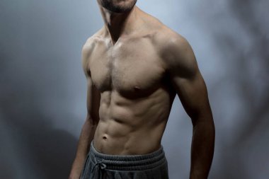 Karın kasları ve göğsü iyi tanımlanmış genç bir erkek cesedi. Gömleksiz gövdeli bir model. Vücut bakımı, erkek sağlığı, fitness, gençlik, erkeklik, sağlık, kilo kaybı, vücut geliştirme 
