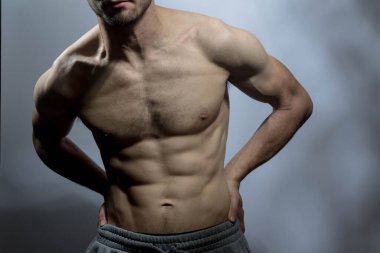 Karın kasları ve göğsü iyi tanımlanmış genç bir erkek cesedi. Gömleksiz gövdeli bir model. Vücut bakımı, erkek sağlığı, fitness, gençlik, erkeklik, sağlık, kilo kaybı, vücut geliştirme 