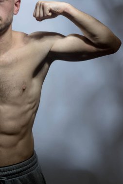 Karın kasları ve göğsü iyi tanımlanmış genç bir erkek cesedi. Gömleksiz gövdesi olan kaslı modeller. Vücut bakımı, erkek sağlığı, fitness, gençlik, erkeklik, sağlık, kilo kaybı, vücut geliştirme 
