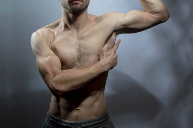 Kasları ve göğüs kasları iyi tanımlanmış genç bir erkek vücudu gömleksiz gövdesini gösteriyor. Vücut bakımı, erkek sağlığı, fitness, gençlik, erkeklik, sağlık, kilo kaybı, vücut geliştirme 