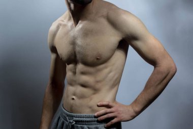 Karın kasları ve göğsü iyi tanımlanmış genç bir erkek cesedi. Gömleksiz gövdeli bir model. Vücut bakımı, erkek sağlığı, fitness, gençlik, erkeklik, sağlık, kilo kaybı, vücut geliştirme 