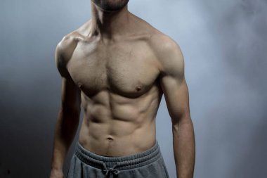 Karın kasları ve göğsü iyi tanımlanmış genç bir erkek cesedi. Gömleksiz gövdeli bir model. Vücut bakımı, erkek sağlığı, fitness, gençlik, erkeklik, sağlık, kilo kaybı, vücut geliştirme 