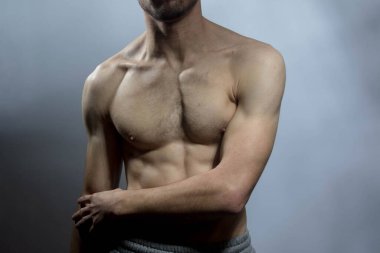 Karın kasları ve göğsü iyi tanımlanmış genç bir erkek cesedi. Gömleksiz gövdeli bir model. Vücut bakımı, erkek sağlığı, fitness, gençlik, erkeklik, sağlık, kilo kaybı, vücut geliştirme 