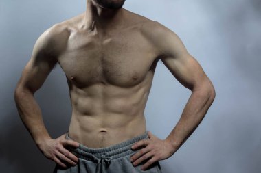 Karın kasları ve göğsü iyi tanımlanmış genç bir erkek cesedi. Gömleksiz gövdeli bir model. Vücut bakımı, erkek sağlığı, fitness, gençlik, erkeklik, sağlık, kilo kaybı, vücut geliştirme 