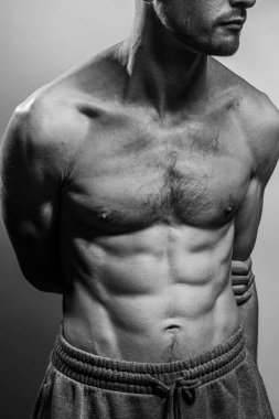 Karın kasları ve göğsü iyi tanımlanmış genç bir erkek cesedi. Gömleksiz gövdeli bir model. Vücut bakımı, erkek sağlığı, fitness, gençlik, erkeklik, sağlık, kilo kaybı, vücut geliştirme 