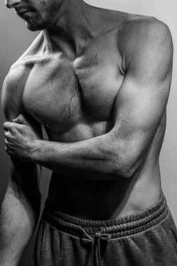 Karın kasları ve göğsü iyi tanımlanmış genç bir erkek cesedi. Gömleksiz gövdeli bir model. Vücut bakımı, erkek sağlığı, fitness, gençlik, erkeklik, sağlık, kilo kaybı, vücut geliştirme 