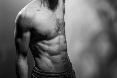 Karın kasları ve göğsü iyi tanımlanmış genç bir erkek cesedi. Gömleksiz gövdeli bir model. Vücut bakımı, erkek sağlığı, fitness, gençlik, erkeklik, sağlık, kilo kaybı, vücut geliştirme 