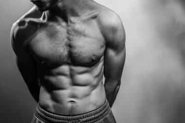 Karın kasları ve göğsü iyi tanımlanmış genç bir erkek cesedi. Gömleksiz gövdeli bir model. Vücut bakımı, erkek sağlığı, fitness, gençlik, erkeklik, sağlık, kilo kaybı, vücut geliştirme 