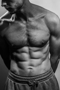 Karın kasları ve göğsü iyi tanımlanmış genç bir erkek cesedi. Gömleksiz gövdeli bir model. Vücut bakımı, erkek sağlığı, fitness, gençlik, erkeklik, sağlık, kilo kaybı, vücut geliştirme 