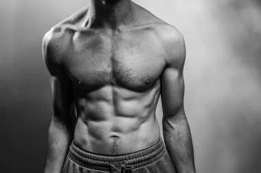 Karın kasları ve göğsü iyi tanımlanmış genç bir erkek cesedi. Gömleksiz gövdeli bir model. Vücut bakımı, erkek sağlığı, fitness, gençlik, erkeklik, sağlık, kilo kaybı, vücut geliştirme 