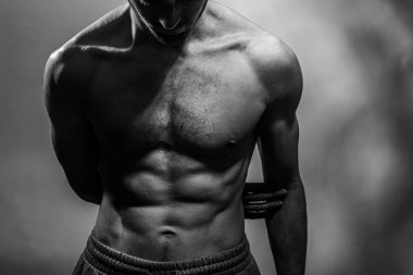 Karın kasları ve göğsü iyi tanımlanmış genç bir erkek cesedi. Gömleksiz gövdeli bir model. Vücut bakımı, erkek sağlığı, fitness, gençlik, erkeklik, sağlık, kilo kaybı, vücut geliştirme 