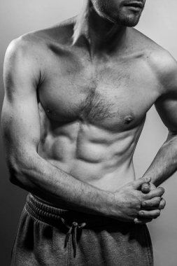 Karın kasları ve göğsü iyi tanımlanmış genç bir erkek cesedi. Gömleksiz gövdeli bir model. Vücut bakımı, erkek sağlığı, fitness, gençlik, erkeklik, sağlık, kilo kaybı, vücut geliştirme 