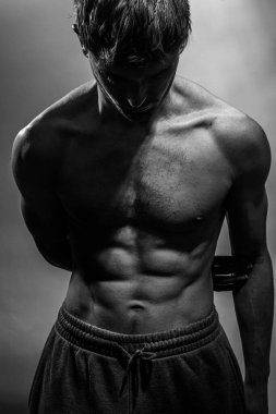 Karın kasları ve göğsü iyi tanımlanmış genç bir erkek cesedi. Gömleksiz gövdeli bir model. Vücut bakımı, erkek sağlığı, fitness, gençlik, erkeklik, sağlık, kilo kaybı, vücut geliştirme 