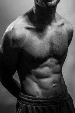 Karın kasları ve göğsü iyi tanımlanmış genç bir erkek cesedi. Gömleksiz gövdeli bir model. Vücut bakımı, erkek sağlığı, fitness, gençlik, erkeklik, sağlık, kilo kaybı, vücut geliştirme 
