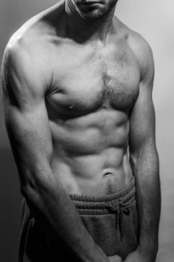 Karın kasları ve göğsü iyi tanımlanmış genç bir erkek cesedi. Gömleksiz gövdeli bir model. Vücut bakımı, erkek sağlığı, fitness, gençlik, erkeklik, sağlık, kilo kaybı, vücut geliştirme 
