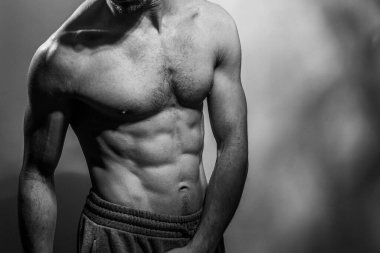 Karın kasları ve göğsü iyi tanımlanmış genç bir erkek cesedi. Gömleksiz gövdeli bir model. Vücut bakımı, erkek sağlığı, fitness, gençlik, erkeklik, sağlık, kilo kaybı, vücut geliştirme 