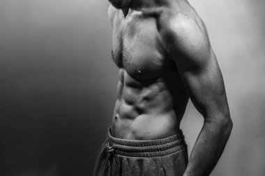 Karın kasları ve göğsü iyi tanımlanmış genç bir erkek cesedi. Gömleksiz gövdeli bir model. Vücut bakımı, erkek sağlığı, fitness, gençlik, erkeklik, sağlık, kilo kaybı, vücut geliştirme 