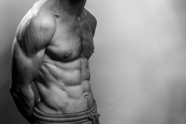 Karın kasları ve göğsü iyi tanımlanmış genç bir erkek cesedi. Gömleksiz gövdeli bir model. Vücut bakımı, erkek sağlığı, fitness, gençlik, erkeklik, sağlık, kilo kaybı, vücut geliştirme 