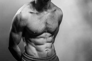 Karın kasları ve göğsü iyi tanımlanmış genç bir erkek cesedi. Gömleksiz gövdeli bir model. Vücut bakımı, erkek sağlığı, fitness, gençlik, erkeklik, sağlık, kilo kaybı, vücut geliştirme 