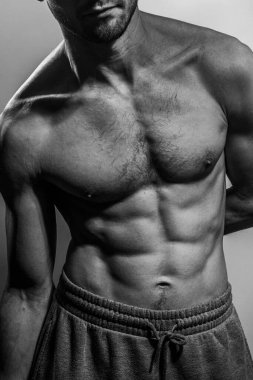 Karın kasları ve göğsü iyi tanımlanmış genç bir erkek cesedi. Gömleksiz gövdeli bir model. Vücut bakımı, erkek sağlığı, fitness, gençlik, erkeklik, sağlık, kilo kaybı, vücut geliştirme 