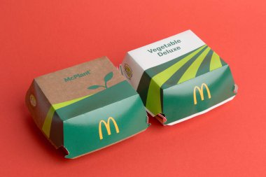 London, United Kingdom, 12th November 2024:- A view of a McDonalds Vegetable Deluxe and McPlant, against a Red background clipart