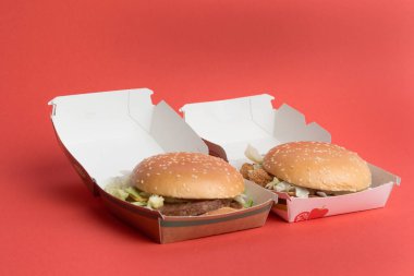 London, United Kingdom, 12th November 2024:- A view of a McDonalds Vegetable Deluxe and McPlant, against a Red background clipart