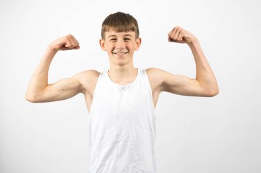 15 yaşında genç bir çocuk, beyaz bir arka plana karşı stüdyo çekimlerini sürdürüyor.