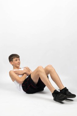 On beş yaşında, beyaz bir arka planda film çeken, mekik çeken bir çocuk.